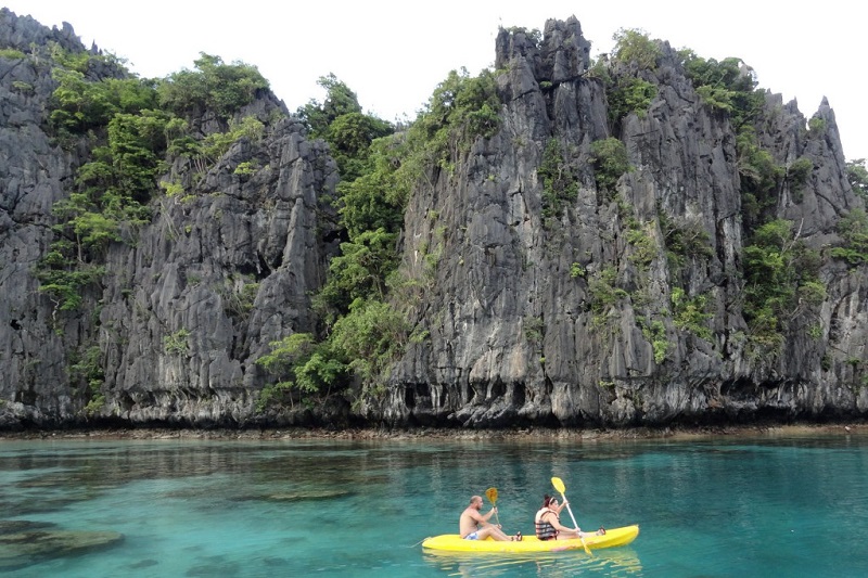 Khách du lịch chèo thuyền kayak trong đầm nhỏ của El Nido 