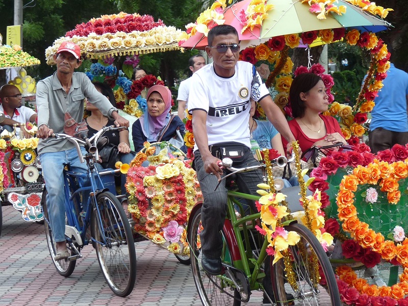 Khách du lịch hào hứng ngồi xe trishaw chạy quanh phố biển Malacca