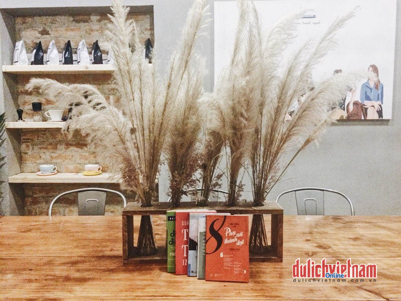 Góc nhỏ trưng bày các sản phẩm cà phê Việt bình hoa cỏ hồng mang đến cảm giác nhẹ nhàng và vài cuốn sách cho thực khách giết thời gian