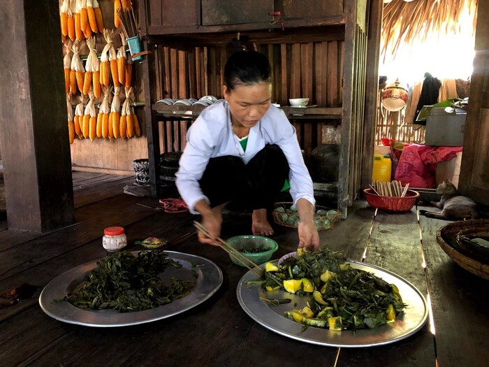 Một người dân tộc Mường đang chuẩn bị món rau rừng đồ cho bữa cơm gia đình.