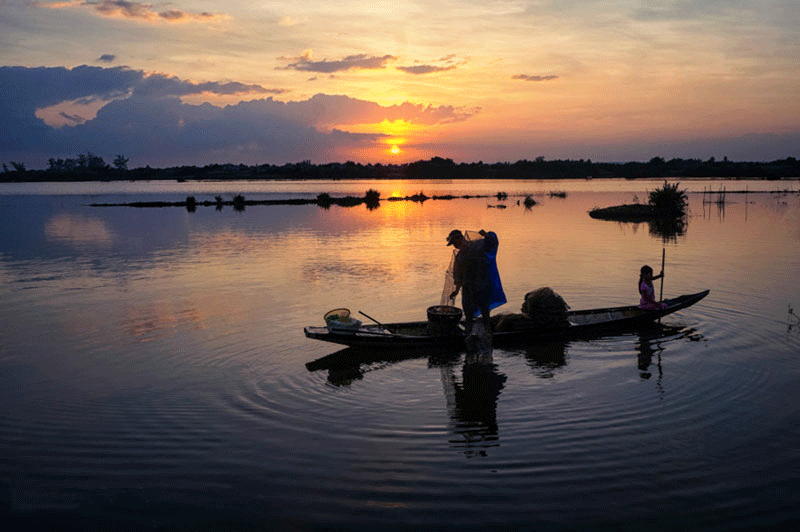 Ngư dân quăng lưới kéo chài giữa hồ