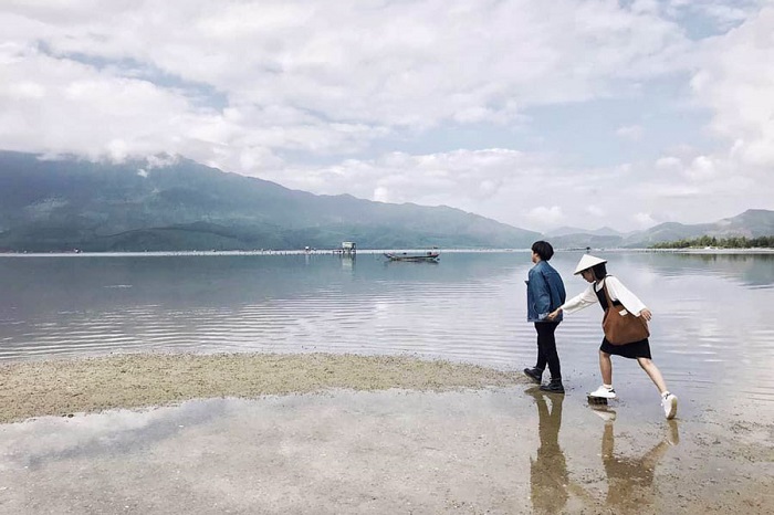 đôi trai gái đi dạo trên mặt hồ khi du lịch đầm Lập An Huế