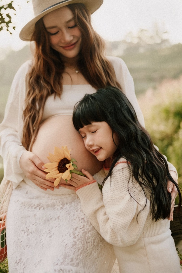 Chị cả Destiny dịu dàng lắng nghe nhịp tim của thành viên mới đang lớn dần trong bụng mẹ Nhã Phương. Ảnh: Facebook nhân vật