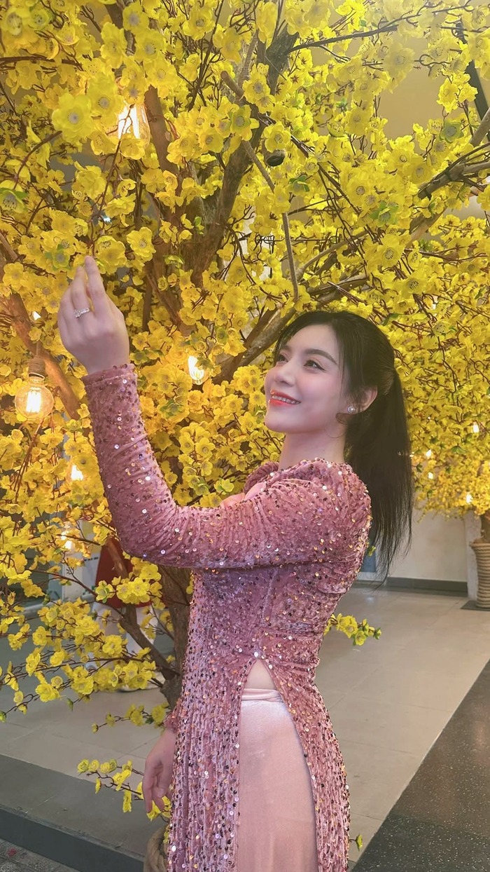 Lê Xuân Nghi khoe nụ cười tươi tắn bên nhành mai vàng ngày Tết. Ảnh: FBNV