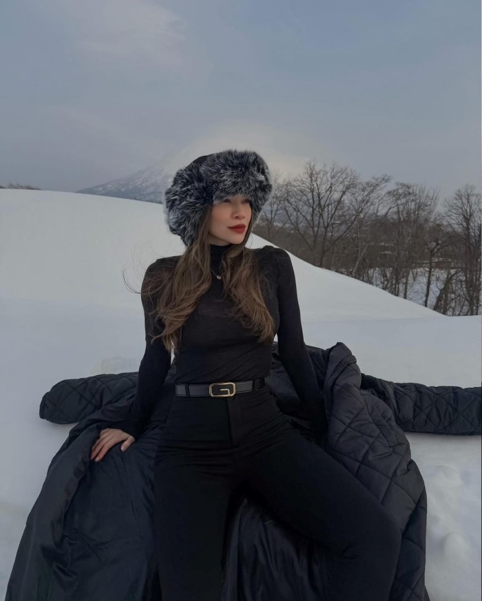 Giữa khung cảnh tuyết trắng, nữ ca sĩ chọn phong cách Thu Đông thanh lịch với áo phao dáng dài kết hợp quần legging, phối cùng trang phục đơn sắc, thắt lưng da và mũ lông, vừa giữ ấm vừa toát lên vẻ sành điệu.