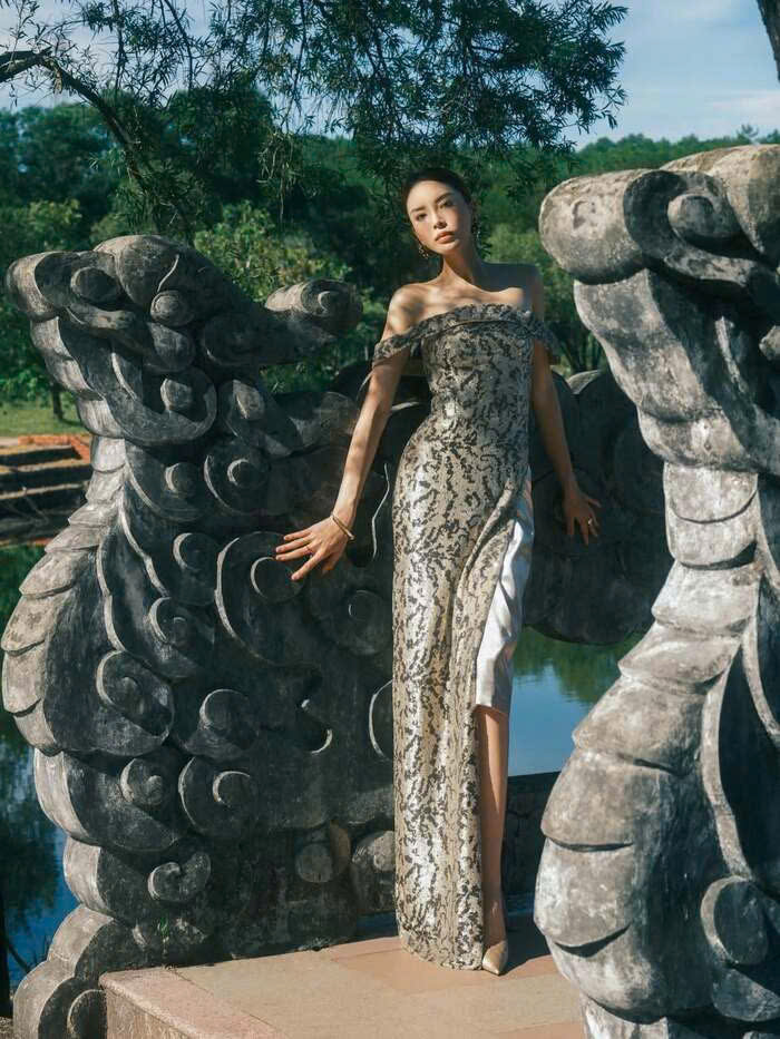 Diện thiết kế ánh kim bắt sáng, Kỳ Duyên đứng giữa không gian đá xám trầm mặc, khai thác hiệu ứng ánh sáng tự nhiên để làm nổi bật đường nét hình thể và cấu trúc trang phục. Ảnh: Instagram nhân vật