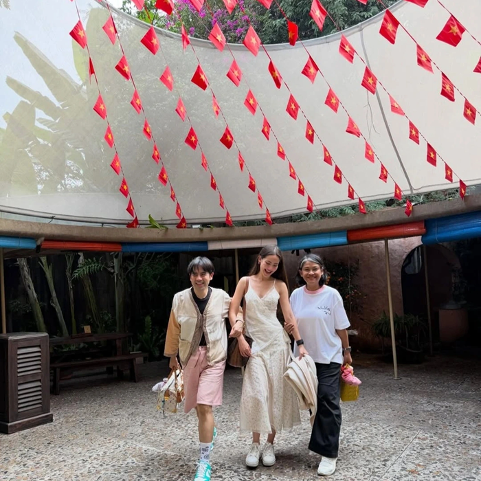 Yaya cùng mẹ và stylist check-in dưới ánh cờ đỏ sao vàng tại TP HCM. Ảnh: Instagram nhân vật