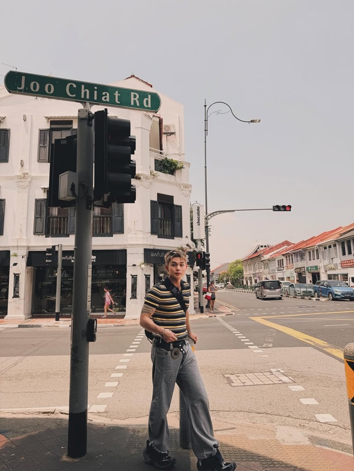 Ca sĩ Jun Phạm tạo dáng tại khu phố Joo Chiat Road, nổi bật với dãy nhà nhiều màu sắc. Ảnh: NVCC