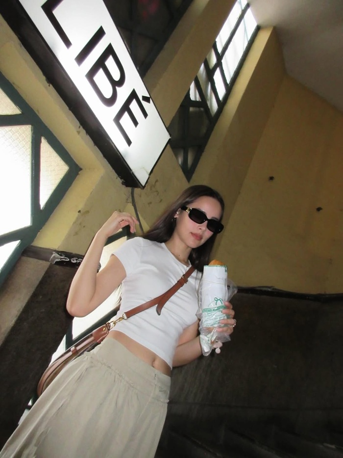 Yaya Urassaya dạo phố tại TP.HCM, tay cầm ổ bánh mì dân dã, ghi lại khoảnh khắc gần gũi giữa đời thường. Ảnh: Instagram nhân vật