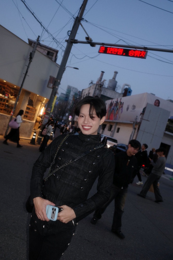 Ở set đồ đen, Pháp Kiều lựa chọn áo cổ cao dáng ôm, thiết kế là với hàng nút và chi tiết dây đai mang hơi hướng military. Phần thân áo ôm gọn giúp tôn lên vóc dáng, đồng thời tạo cảm giác gọn gàng, tôn dáng. Kết hợp cùng đó là quần ống loe đen, điểm nhấn bằng các chi tiết kim loại chạy dọc hai bên, vừa tạo hiệu ứng kéo dài đôi chân, vừa tăng thêm độ “edgy” cho tổng thể.