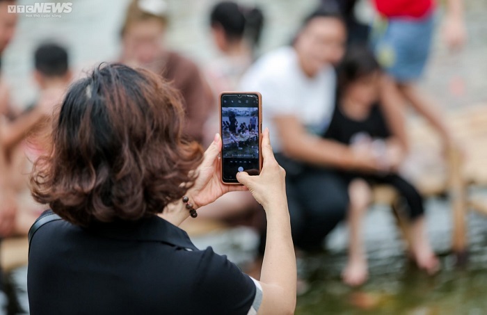 Du khách đến trải nghiệm ở hồ cá koi Hồ Tây