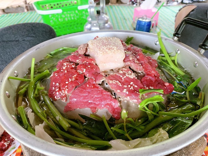 Từng lát thịt bò leo núi An Giang được thái mỏng, ướp với vừng và trứng rồi nướng trên nồi có phần nhô lên ở giữa, trông rất giống một ngọn núi nhỏ.