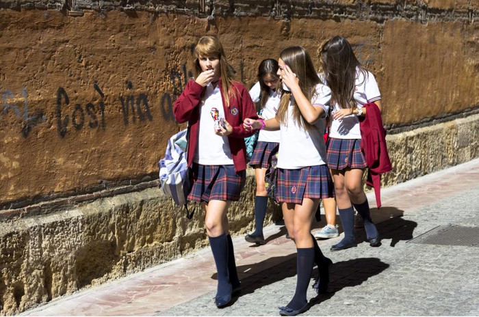 Nữ sinh Tây Ban Nha nhìn rất thời trang trong bộ đồng phục gồm tất dài màu đen, váy kẻ xếp ly, áo thun trắng và áo khoác mỏng gắn logo trường.