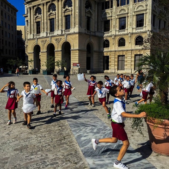 Học sinh tiểu học ở Cuba thoải mái vui đùa với bộ đồng phục quần shorts cho nam và chân váy cho nữ, kết hợp cùng áo phông trắng bẻ cổ, thêm khăn quàng màu xanh dương khi được kết nạp vào đội.