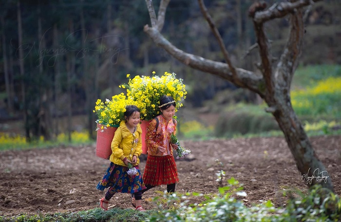 Trẻ em nơi làng cổ Ma Lé với chiếc gùi chở đầy hoa trên lưng.