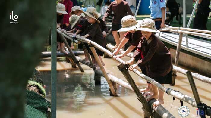 băng qua cầu khỉ tại địa điểm dã ngoại cho trẻ em ở TP. HCM